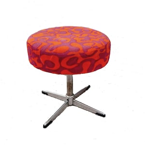 May include: A swivel stool with a red and purple patterned fabric seat and a chrome base with four legs.