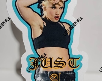 Puede incluir: Una pegatina con una mujer de pelo rubio que lleva un top negro sin mangas y una falda de cuadros. El texto "Just a Girl" está escrito en una fuente estilizada.