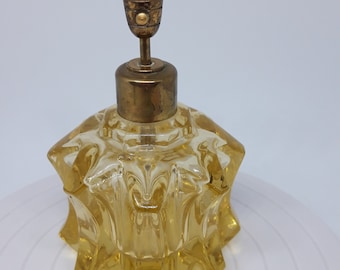 Botella de perfume de cristal vintage de vidrio amarillo con fondo pulido.