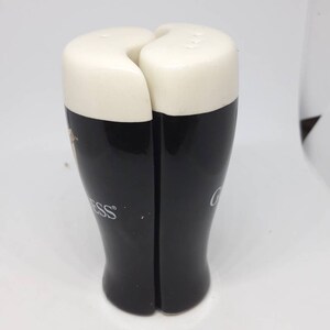 Puede incluir: Un juego de dos saleros y pimenteros de cer&aacute;mica negra y blanca con forma de vasos de pinta de Guinness. Los saleros tienen la parte superior blanca y la inferior negra con el logotipo de Guinness.
