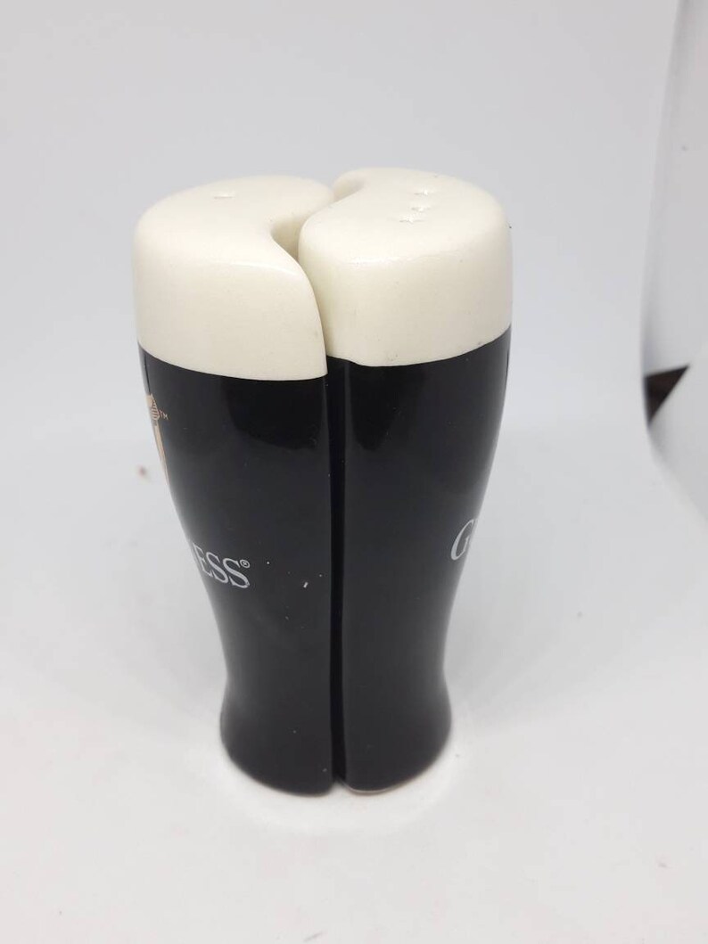 Puede incluir: Un juego de dos saleros y pimenteros de cer&aacute;mica negra y blanca con forma de vasos de pinta de Guinness. Los saleros tienen la parte superior blanca y la inferior negra con el logotipo de Guinness.