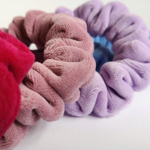Pu&ograve; includere: Tre scrunchies di diversi colori: rosa, viola e rosso. Gli scrunchies sono realizzati in tessuto morbido e peloso.