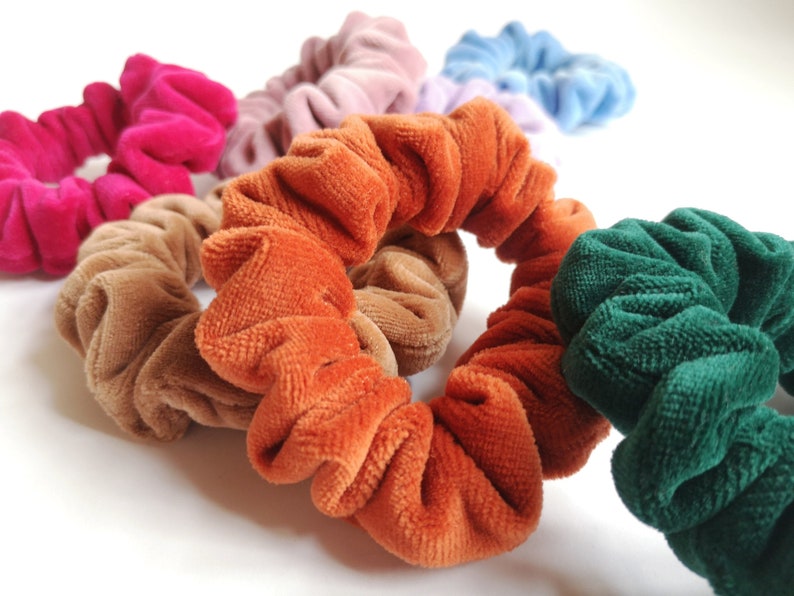 Pu&ograve; includere: Un set di scrunchies colorati realizzati in tessuto morbido e vellutato. Gli scrunchies sono disponibili in una variet&agrave; di colori, tra cui rosa, marrone, arancione, verde e blu.