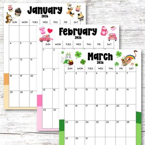 May include: A set of three 2026 monthly calendars. The January calendar has cupcake and dog illustrations. February features a pink car and coffee cup. March includes a cat with a rainbow and shamrocks.