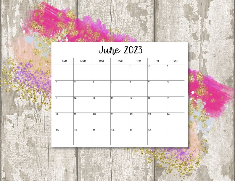 Puede incluir: Un calendario blanco para junio de 2023, con un dise&ntilde;o de cuadr&iacute;cula simple. El calendario est&aacute; sobre un fondo de madera gris claro desgastado, acentuado con vibrantes pinceladas rosas y doradas.