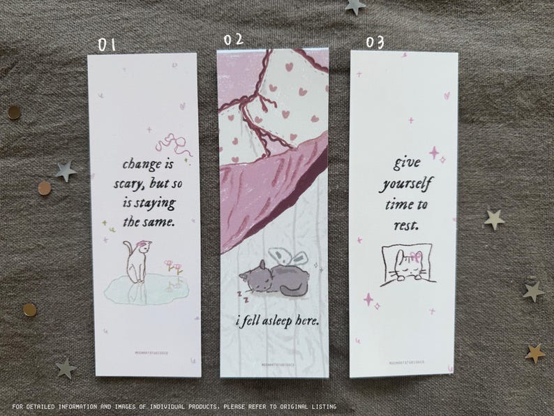 May include: Three pink and white bookmarks with illustrations of cats and inspirational quotes. The first bookmark says "change is scary, but so is staying the same." The second bookmark says "i fell asleep here." The third bookmark says "give yourself time to rest."