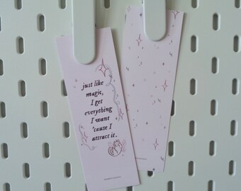 May include: Two pink bookmarks with a quote on one and a pattern of stars on the other. The quote reads "just like magic, I get everything I want 'cause I attract it."