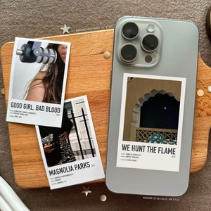 May include: Three minimalist movie poster prints featuring a woman singing into a microphone, a woman in a sparkly dress, and a photo of an archway. The posters are printed on white paper with black text and are titled "Good Girl, Bad Blood", "Magnolia Parks", and "We Hunt the Flame".