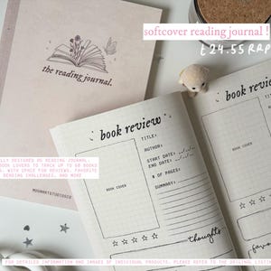 May include: A pink and white reading journal with a book illustration on the cover. The journal has a section for book reviews with space for the title, author, start and end dates, number of pages, a summary, and thoughts. The journal also has a section for favorite quotes. The text on the cover reads "the reading journal."