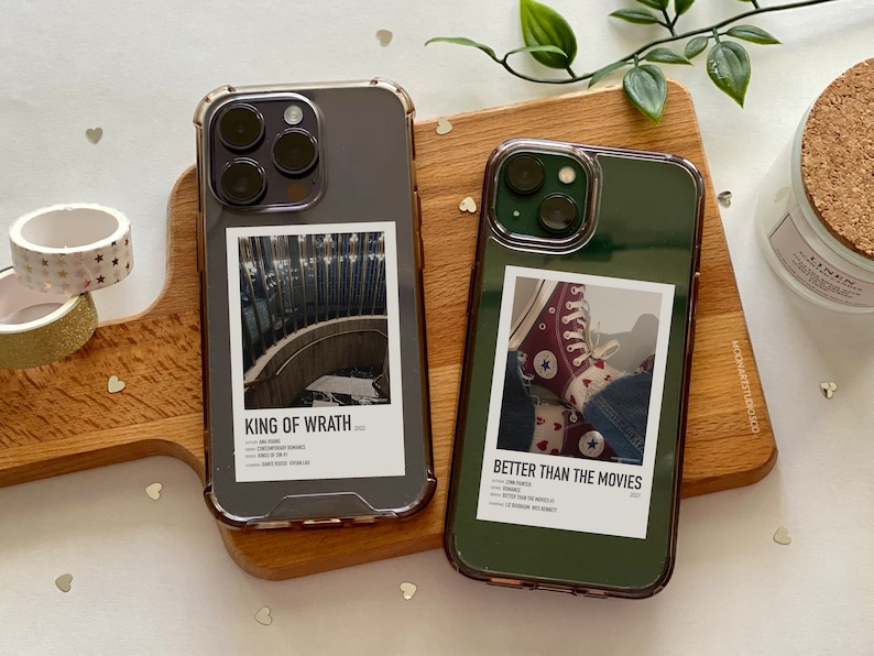 May include: Two clear phone cases with black and green borders. The case on the left has a photo of a staircase with the text "KING OF WRATH 2022". The case on the right has a photo of red and white sneakers with the text "BETTER THAN THE MOVIES 2021".
