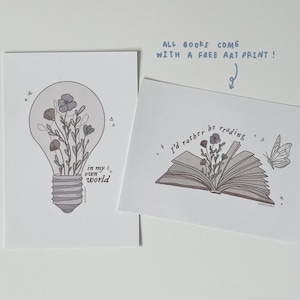 Puede incluir: Dos impresiones de arte imprimibles con una bombilla y un libro abierto con flores que crecen de ellos. La impresi&oacute;n de la bombilla dice "en mi propio mundo" y la impresi&oacute;n del libro dice "Prefiero leer".
