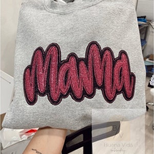 May include: A gray sweatshirt with the word "Mama" embroidered in pink glitter with a black outline.