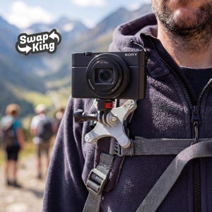 Peut inclure: Un appareil photo numérique Sony noir monté sur un harnais de poitrine. L'appareil photo est fixé à un support blanc et gris. L'image comprend le texte "Swap King" dans un logo.