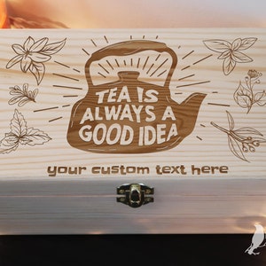 May include: A wooden tea box with a light wood finish. The lid is engraved with a teapot and the text "Tea is always a good idea". The box also has a space for a custom text inscription.