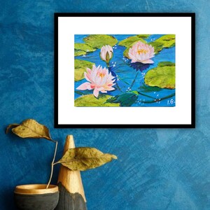 May include: A painting of pink water lilies with green lily pads floating on a blue pond. The painting is framed in black and has the signature "I.G." in the bottom right corner.