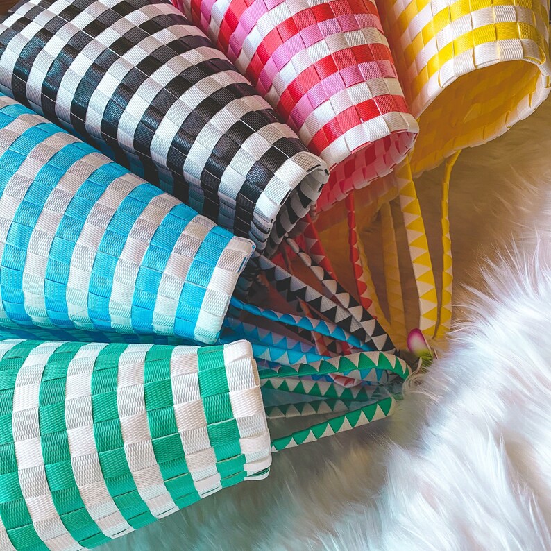 May include: A set of colorful striped woven bags with handles. The bags are made of a woven plastic material and come in black and white, blue and white, green and white, pink and white, and yellow and white.