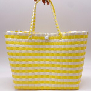 May include: Yellow and white striped woven tote bag with a white handle.