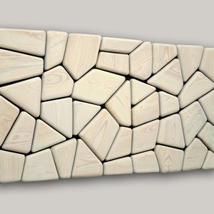 May include: A wall art piece made of light wood, featuring a geometric pattern of irregular shapes. The wood pieces are arranged in a mosaic-like design, creating a modern and abstract look.