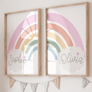 May include: Two framed prints featuring rainbow designs with the names "Sophie" and "Olivia" written in a cloud beneath each rainbow.
