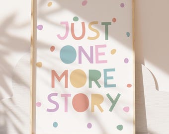May include: A colourful print with the text "JUST ONE MORE STORY" in a white frame. The text is in a variety of colours, including pink, blue, yellow, and green. The background is white with small colourful dots.