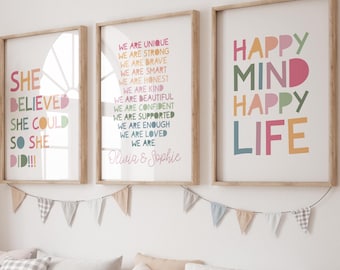 May include: Three framed prints with inspirational messages in colorful text. The first print says "She Believed She Could So She Did!!!". The second print says "We Are Unique, We Are Strong, We Are Brave, We Are Smart, We Are Honest, We Are Kind, We Are Beautiful, We Are Confident, We Are Supported, We Are Enough, We Are Loved, We Are, Olivia & Sophie". The third print says "Happy Mind Happy Life".