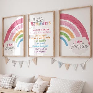 Pode incluir: Três impressões emolduradas com desenhos de arco-íris e afirmações positivas. A primeira impressão diz "I dream big I AM Enough". A segunda impressão diz "Little Reminders" e lista afirmações positivas. A terceira impressão diz "I am Loved and Supported I am Happy I am Thoughtful I Belong I AM Amelia".
