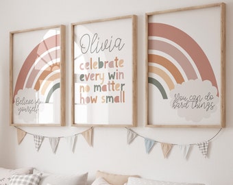 May include: Three framed prints with rainbow designs and inspirational quotes. The prints are hung on a white wall above a wooden bench with pillows and storage bins. The quotes are "Believe in yourself", "Olivia celebrate every win no matter how small", and "You can do hard things".