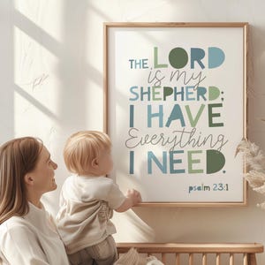 May include: A framed print with the text "THE LORD is my SHEPHERD; I HAVE Everything I NEED. psalm 23:1" in shades of blue and green. A woman and a baby are in the foreground.