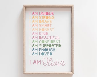 Puede incluir: Una impresión enmarcada con fondo blanco y texto colorido que dice "Soy única, soy fuerte, soy valiente, soy inteligente, soy honesta, soy amable, soy hermosa, soy segura de mí misma, soy apoyada, soy suficiente, soy amada, soy Olivia".