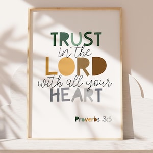 May include: A framed wall art print featuring the text TRUST in the LORD with all your HEART and Proverbs 3:5. The word TRUST is in green, LORD is in tan and brown, and HEART is in grey. The text is displayed in a mix of block and script fonts.