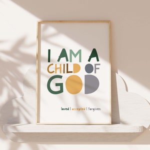 May include: A framed print with the text "I am a child of God" in green, yellow, and gray letters. The text "loved | accepted | forgiven" is printed below in smaller letters.
