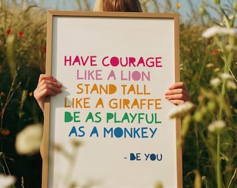 May include: A framed print with the words "HAVE COURAGE LIKE A LION, STAND TALL LIKE A GIRAFFE, BE AS PLAYFUL AS A MONKEY - BE YOU" in colorful text. The frame is light brown, and the background is a field of wildflowers.