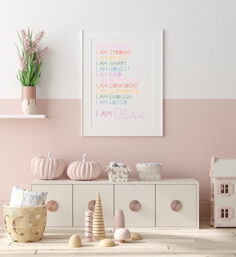 Puede incluir: Una impresi&oacute;n enmarcada blanca con un fondo rosa y texto de color arco&iacute;ris que dice "Soy &uacute;nica, soy fuerte, soy valiente, soy inteligente, soy honesta, soy amable, soy hermosa, soy segura de m&iacute; misma, soy apoyada, soy suficiente, soy amada, soy Olivia".