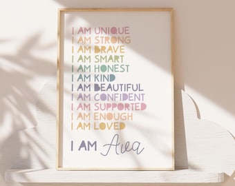 Puede incluir: Una impresión enmarcada con fondo blanco y texto colorido que dice "Soy única, soy fuerte, soy valiente, soy inteligente, soy honesta, soy amable, soy hermosa, soy segura de mí misma, soy apoyada, soy suficiente, soy amada, soy Ava".