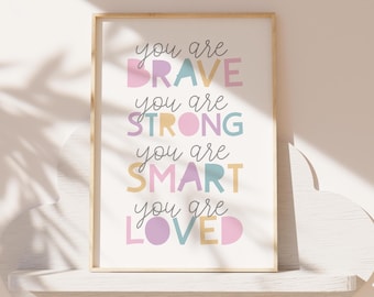 Puede incluir: Una impresión enmarcada con el texto "You are brave, you are strong, you are smart, you are loved" en letras de colores sobre un fondo blanco.