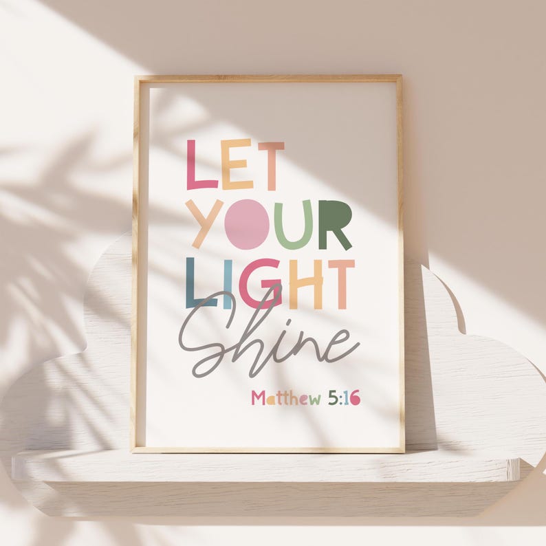 May include: A framed print with the text "Let your light shine" in colorful letters. The text "Matthew 5:16" is printed below in a smaller font.