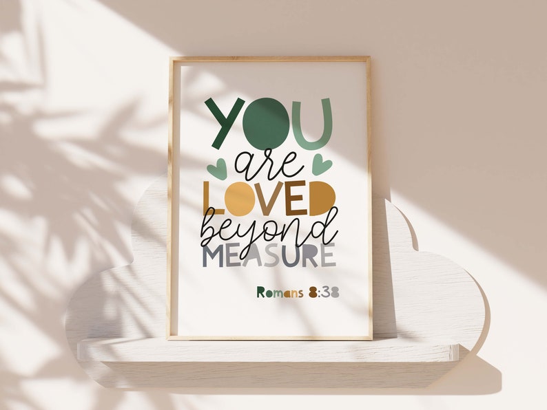 May include: A framed print with a white background and green, yellow, and gray text that reads "You are loved beyond measure Romans 8:38".