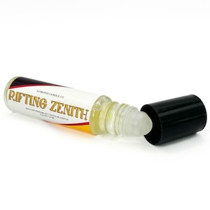 May include: A roll-on perfume oil bottle with the text "Rifting Zenith" in gold lettering. The bottle is clear, with a white label and a black cap. The label also includes the text "Luminis Candle Co."