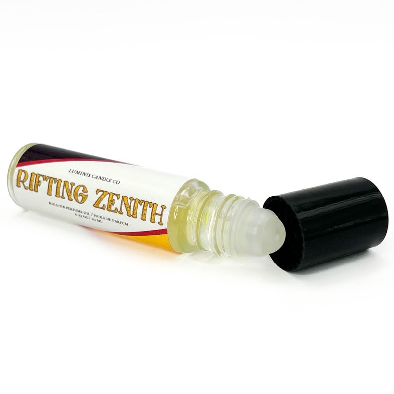 May include: A roll-on perfume oil bottle with the text "Rifting Zenith" in gold lettering. The bottle is clear, with a white label and a black cap. The label also includes the text "Luminis Candle Co."