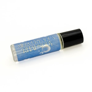 May include: A clear glass roll-on perfume bottle with a black cap. The label reads "MERCURY AQUA RHAPSODY" in white text over a blue background. The bottle contains 0.33 fl oz / 10 ml of perfume.