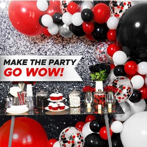 May include: A party decoration set with red, black, white, and silver balloons. The balloons are arranged in a garland shape and include confetti balloons. The text "MAKE THE PARTY GO WOW!" is on a banner in the background.