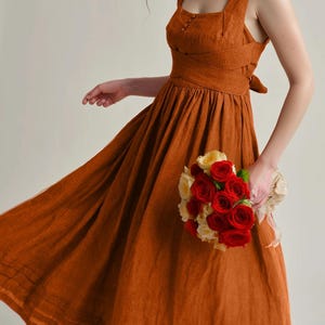 a woman in a dress holding a bouquet of flowers