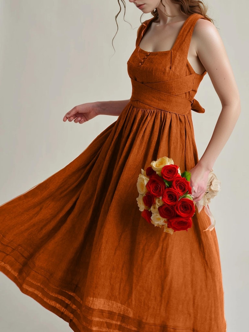 a woman in a dress holding a bouquet of flowers