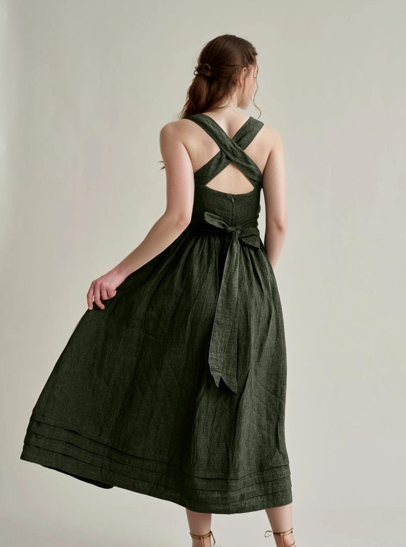 a woman wearing a green dress with a cross back