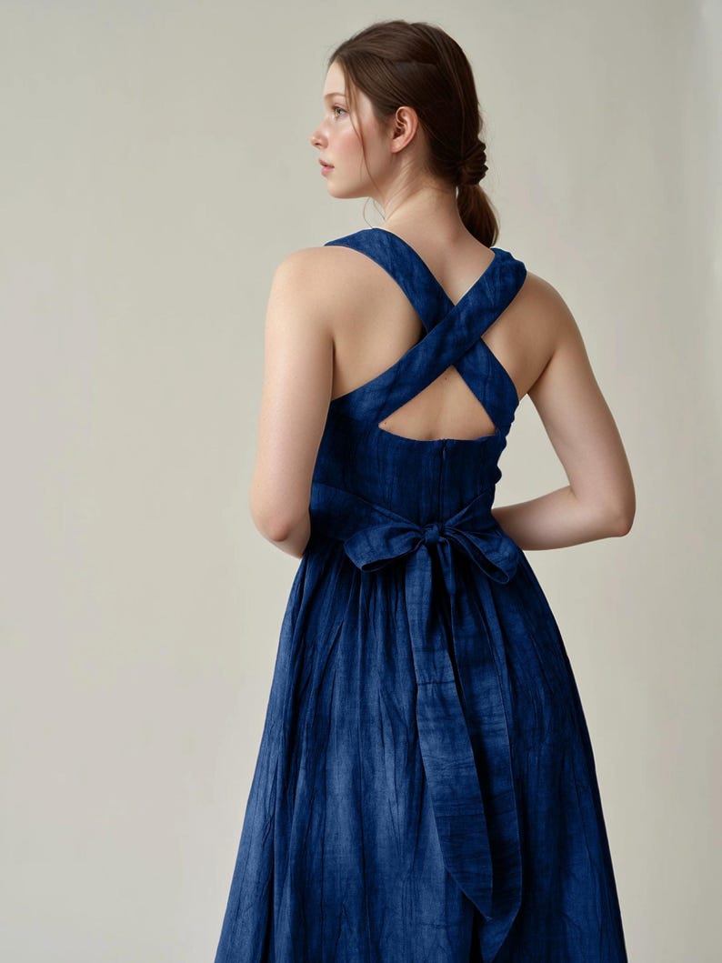 a woman wearing a blue dress with a cross back
