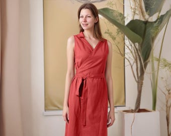 May include: A woman wearing a sleeveless, red wrap dress with a V-neckline and a tie belt.