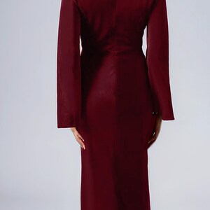 a woman in a red dress is standing