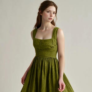 a woman in a green dress poses for a picture