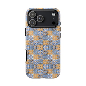 Può includere: Custodia per telefono con un motivo ripetuto di forme geometriche blu e oro. La custodia ha un modulo fotocamera nero e pulsanti laterali neri. Il design ricorda le tradizionali piastrelle.