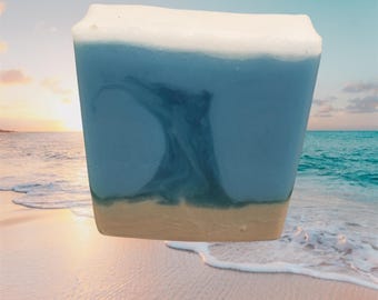 May include: A blue and white soap bar with a swirl design, resembling a wave. The soap has a light brown layer at the bottom.
